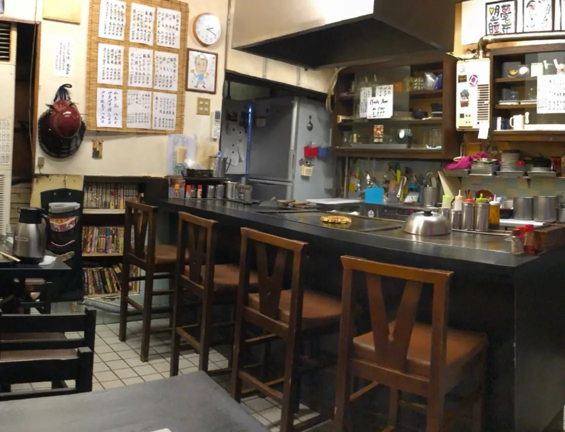 カウンター席と壁一面のお品書きがある小さな食堂